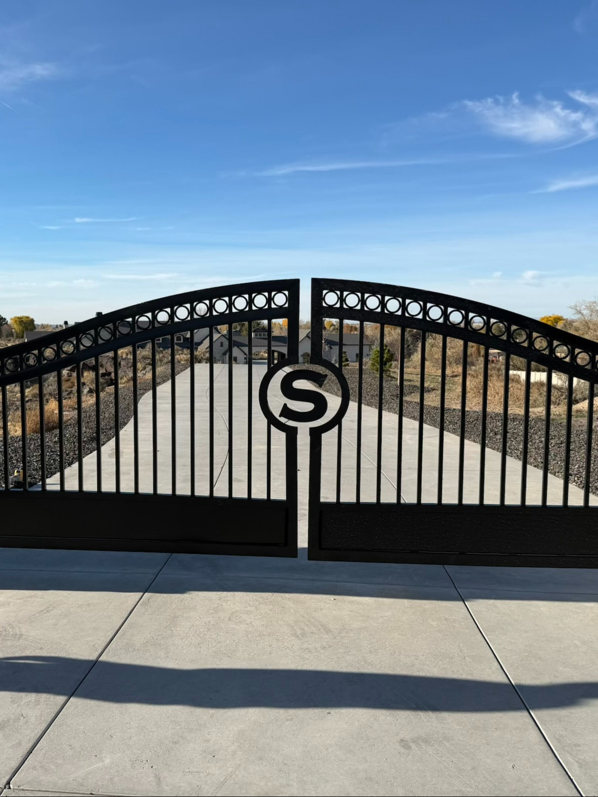 Ornamental driveway gate with monogram