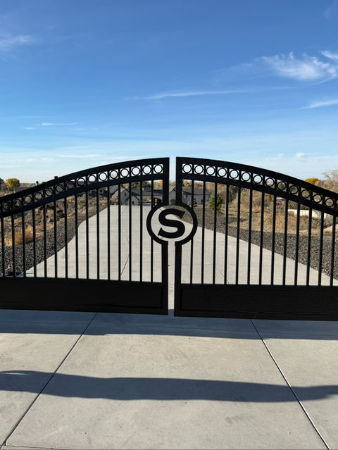 Custom arched driveway gate with S monogram