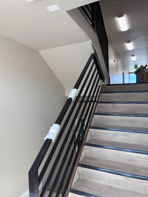 Modern stairwell handrails with black metal balusters
